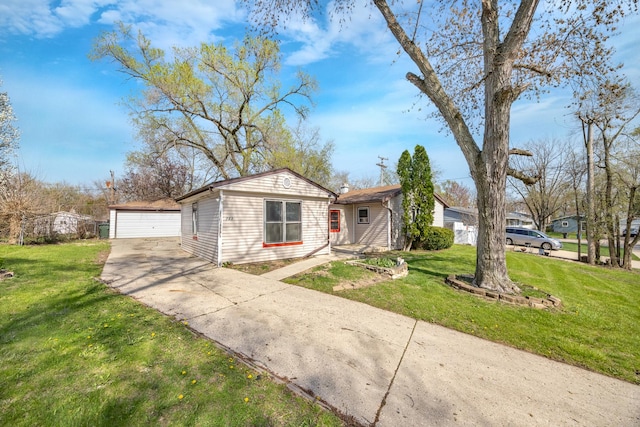 view of front of property featuring a detached garage, an outbuilding, and a front yard