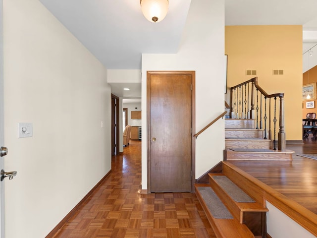 entrance foyer with baseboards, visible vents, and stairway
