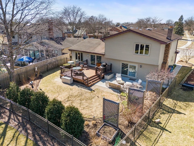 back of house featuring a lawn, an outdoor hangout area, a wooden deck, and a fenced backyard