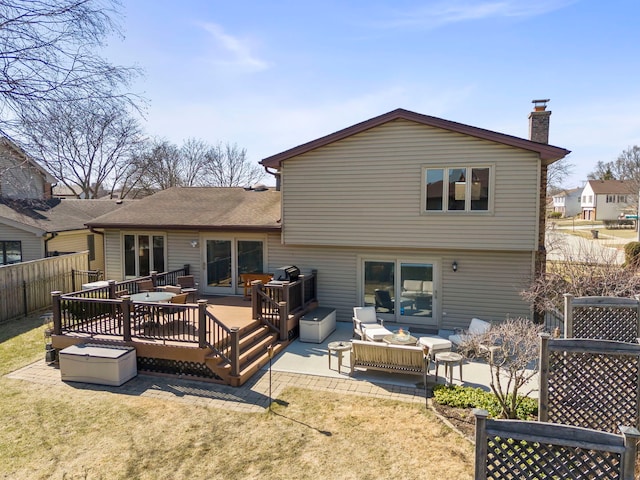 back of house with a chimney, fence, a wooden deck, and a yard