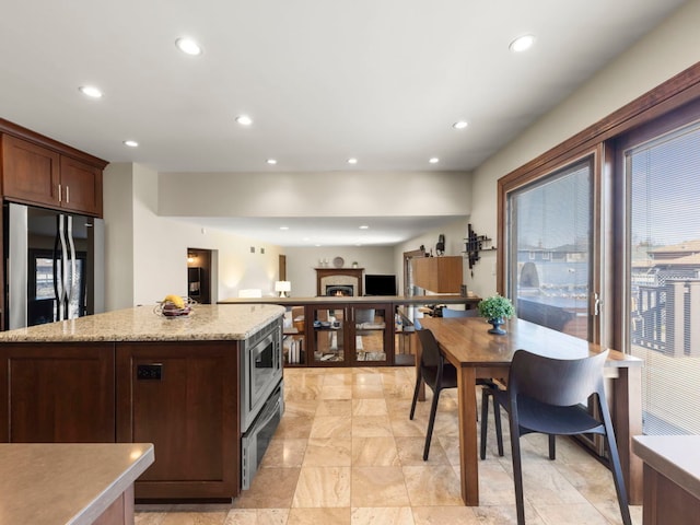 kitchen featuring recessed lighting, dark brown cabinetry, and stainless steel microwave