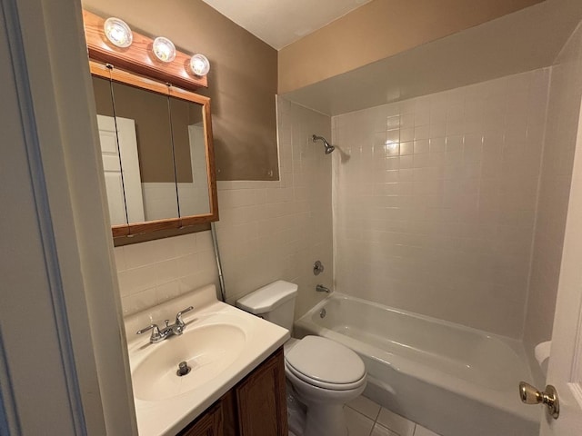 full bath featuring tile walls, toilet, tile patterned floors, vanity, and shower / washtub combination