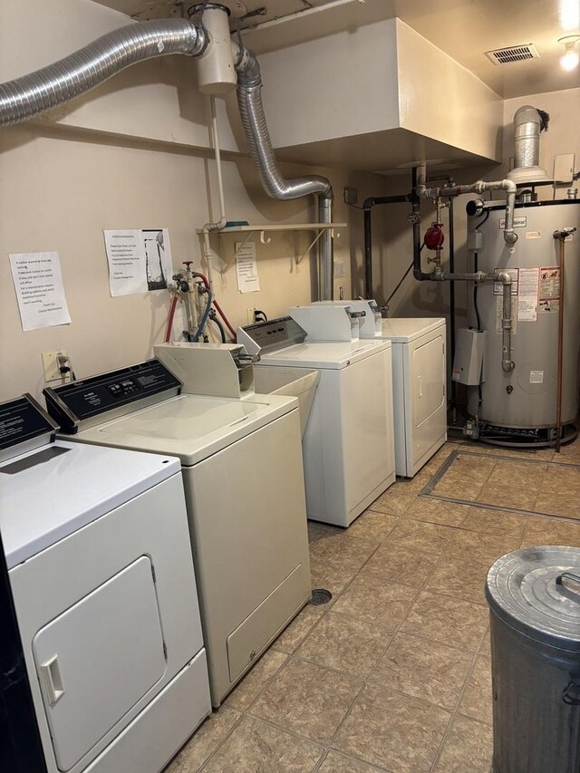 laundry room with washer and clothes dryer, water heater, and visible vents
