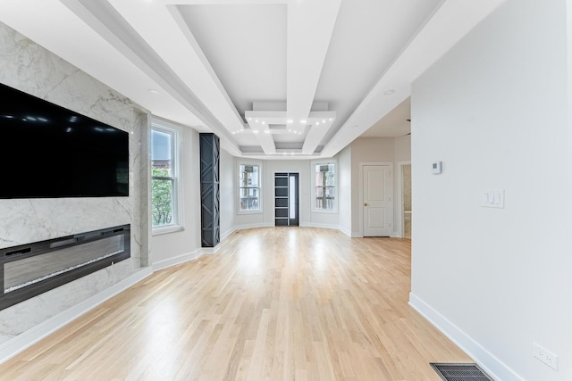 822 N Lockwood Ave, Chicago, IL 60651 - unfurnished living room with light wood-style floors, baseboards, a high end fireplace, a tray ceiling, and visible vents