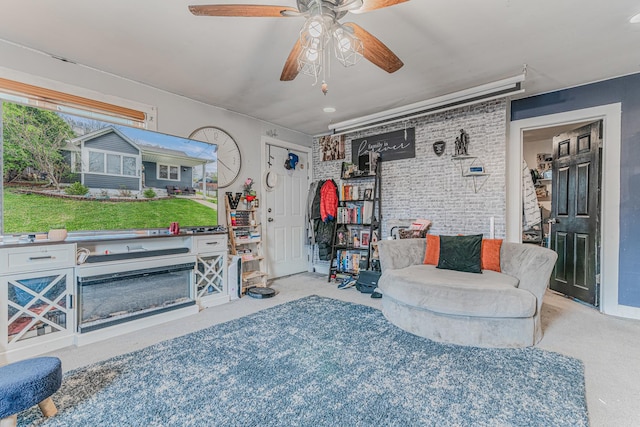 carpeted living room featuring brick wall and a ceiling fan