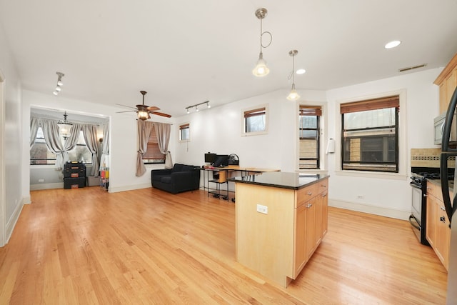 7633 N Greenview Ave Unit 3W, Chicago, IL 60626 - kitchen with light wood-style flooring, dark countertops, a center island, open floor plan, and black gas range