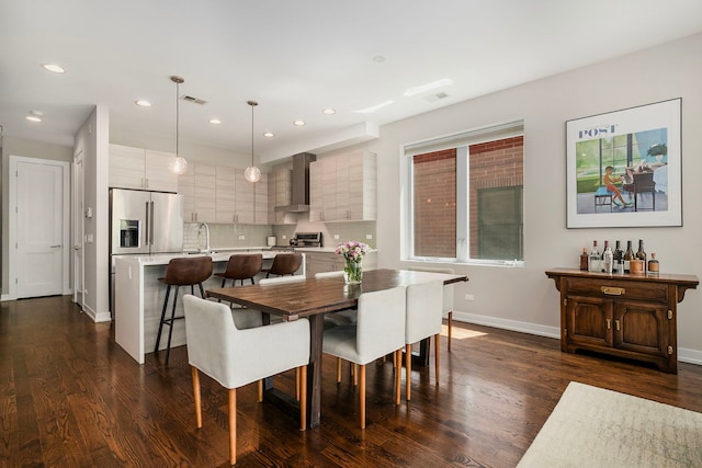 dining space featuring dark wood-style flooring, baseboards, and recessed lighting