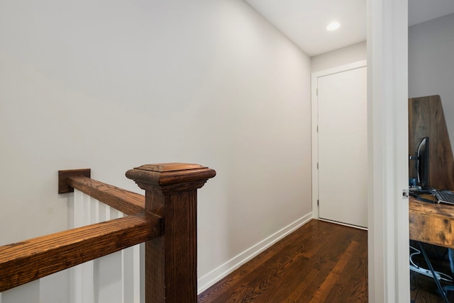 hall with dark wood finished floors, baseboards, an upstairs landing, and recessed lighting