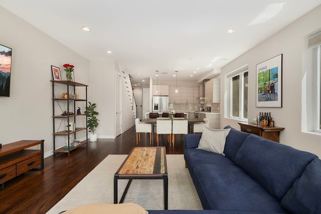 living area with dark wood-type flooring, recessed lighting, and baseboards