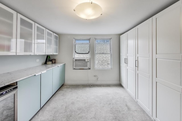 kitchen with cooling unit, glass insert cabinets, light stone counters, light carpet, and wine cooler