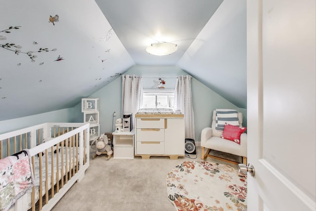 bedroom with a crib, carpet flooring, and vaulted ceiling