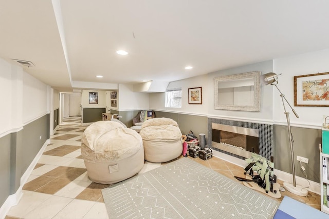 tiled living room with visible vents, recessed lighting, a fireplace, and baseboards