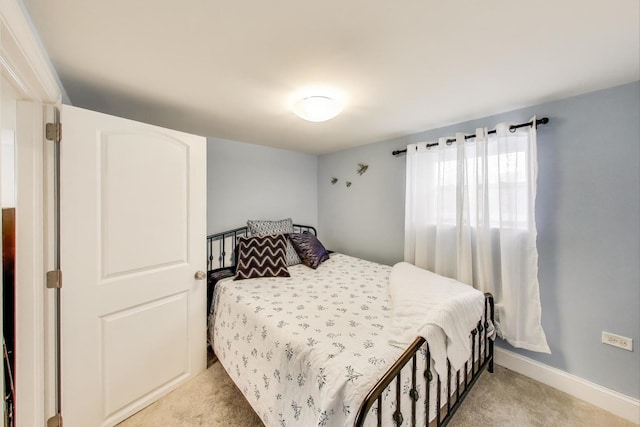 bedroom with baseboards and light colored carpet