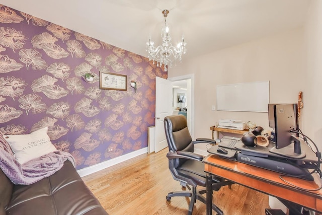 home office featuring baseboards, wallpapered walls, wood finished floors, and a notable chandelier