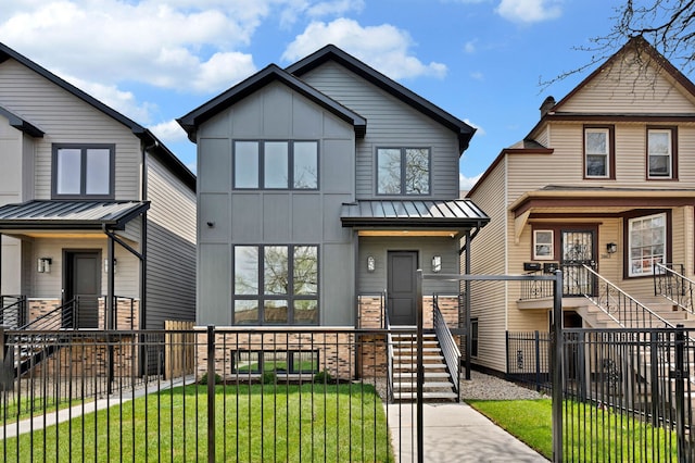 view of front facade featuring fence private yard, a front yard, a standing seam roof, stairs, and board and batten siding