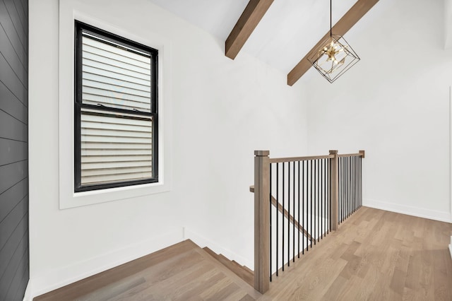 staircase with baseboards, wood finished floors, and beam ceiling