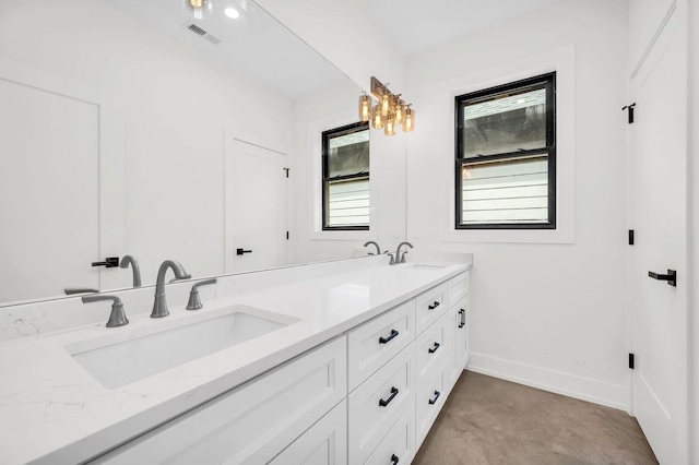 bathroom featuring visible vents, double vanity, baseboards, a sink, and a notable chandelier