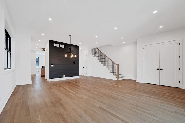 foyer featuring an inviting chandelier, recessed lighting, baseboards, light wood-type flooring, and stairway