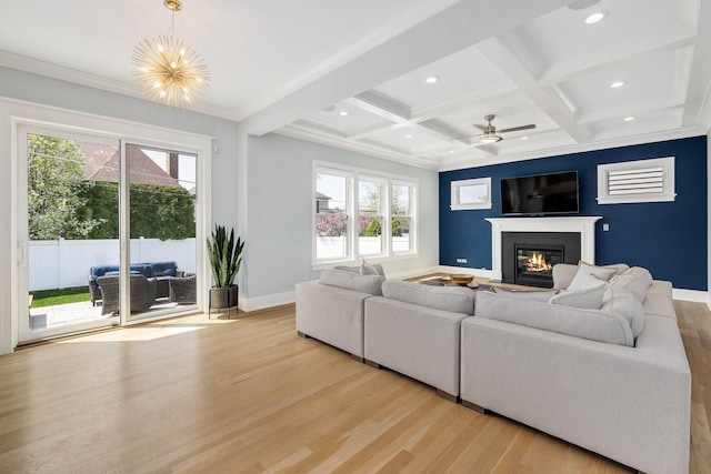 living area with a glass covered fireplace, light wood-style floors, baseboards, recessed lighting, and beamed ceiling