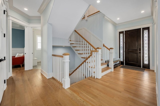 foyer entrance featuring wood finished floors, ornamental molding, recessed lighting, baseboards, and wainscoting