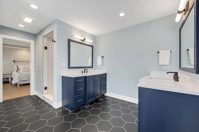 ensuite bathroom featuring tile patterned floors, two vanities, a shower stall, baseboards, and recessed lighting