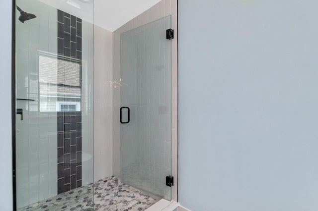 full bath featuring a stall shower and baseboards