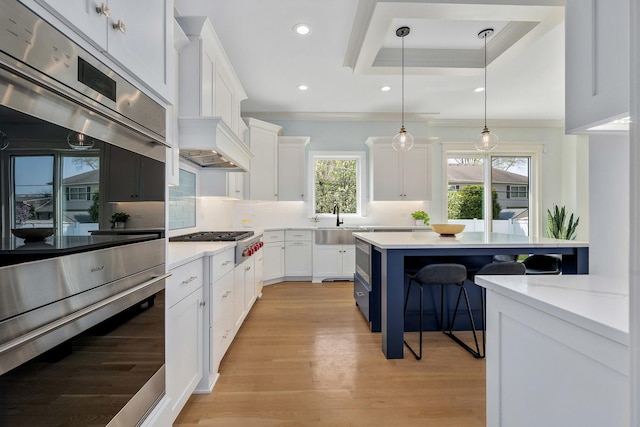 kitchen featuring appliances with stainless steel finishes, light wood-style flooring, a breakfast bar area, decorative backsplash, and recessed lighting