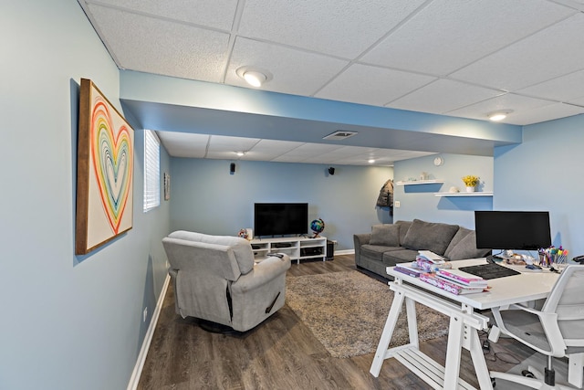 living area with dark wood-type flooring, a paneled ceiling, visible vents, and baseboards