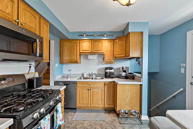 kitchen featuring light countertops, a sink, stainless steel appliances, and tasteful backsplash