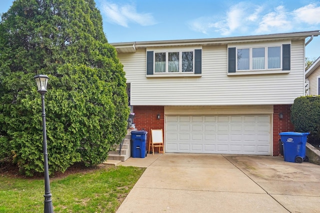 view of front of property with brick siding, an attached garage, and driveway