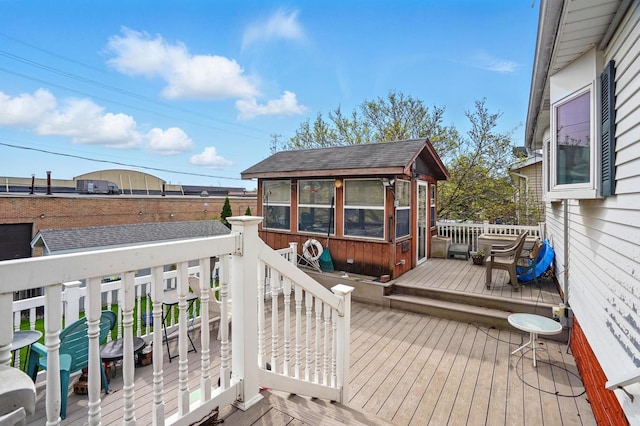 wooden terrace featuring an outbuilding