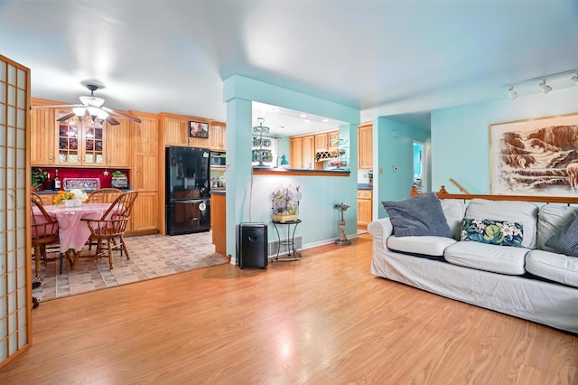 living area with ceiling fan and light wood-type flooring