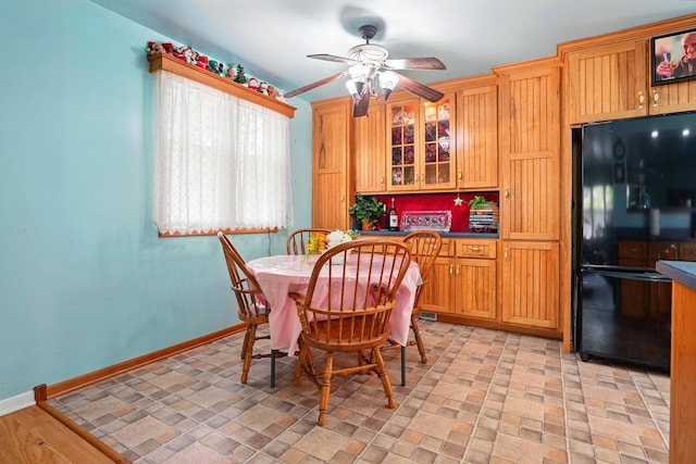 dining space with ceiling fan and baseboards
