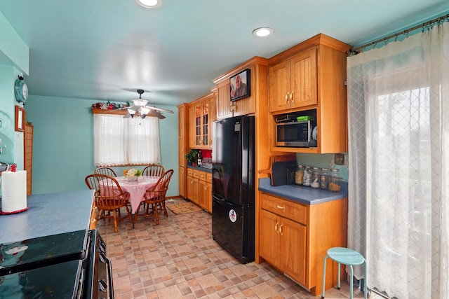 kitchen featuring ceiling fan, electric stove, freestanding refrigerator, stainless steel microwave, and glass insert cabinets