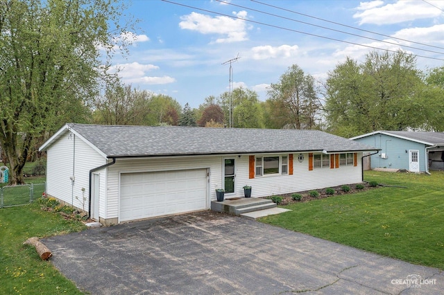 145 W Eisenhower St, Waterman, IL 60556 - ranch-style home featuring a front lawn, aphalt driveway, fence, a shingled roof, and an attached garage