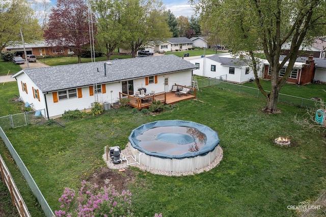 145 W Eisenhower St, Waterman, IL 60556 - rear view of house featuring a deck, a fenced backyard, a fenced in pool, an outdoor fire pit, and a yard