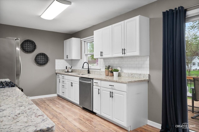 145 W Eisenhower St, Waterman, IL 60556 - kitchen with decorative backsplash, appliances with stainless steel finishes, a sink, baseboards, and white cabinets