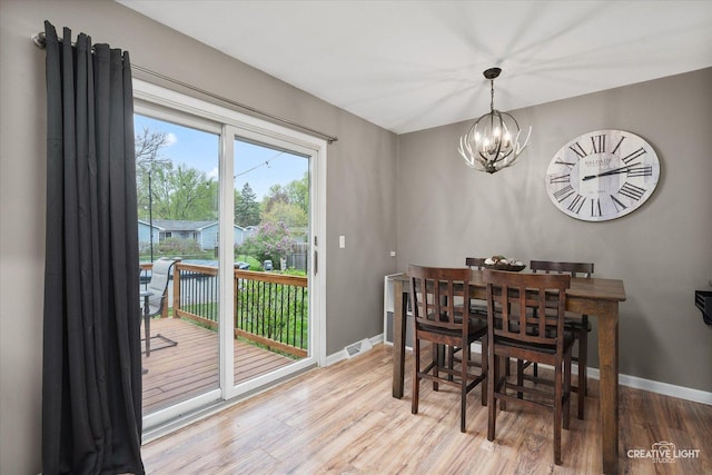 145 W Eisenhower St, Waterman, IL 60556 - dining space with baseboards, wood finished floors, and a notable chandelier