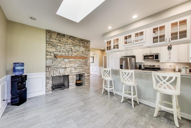 2502 S Hidden Trl, Spring Grove, IL 60081 - kitchen with glass insert cabinets, a breakfast bar, white cabinetry, a peninsula, and appliances with stainless steel finishes