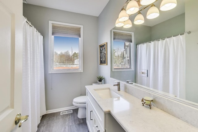 2502 S Hidden Trl, Spring Grove, IL 60081 - full bathroom featuring a healthy amount of sunlight, toilet, baseboards, and visible vents