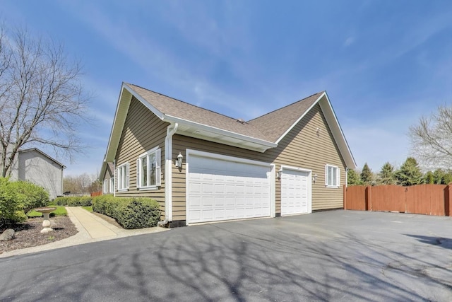 2502 S Hidden Trl, Spring Grove, IL 60081 - view of side of property with an attached garage, fence, a shingled roof, and driveway