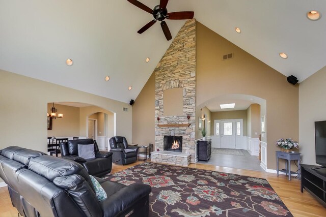 2502 S Hidden Trl, Spring Grove, IL 60081 - living room featuring light wood-style flooring, ceiling fan with notable chandelier, high vaulted ceiling, visible vents, and arched walkways