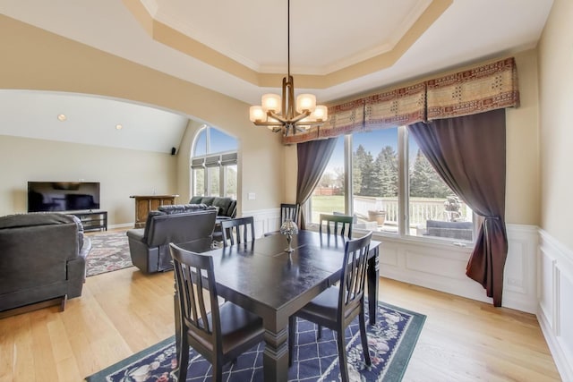 2502 S Hidden Trl, Spring Grove, IL 60081 - dining room with light wood-style floors, a chandelier, wainscoting, and arched walkways