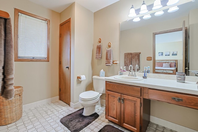 bathroom featuring vanity, baseboards, and toilet
