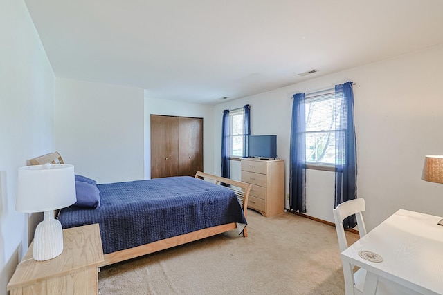 bedroom featuring baseboards, light carpet, and visible vents