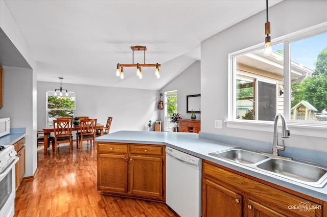 1118 Golden Oaks Pkwy, Aurora, IL 60506 - kitchen featuring white appliances, a sink, light wood-type flooring, a peninsula, and brown cabinetry