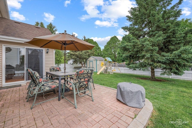 1118 Golden Oaks Pkwy, Aurora, IL 60506 - view of patio featuring a storage shed, outdoor dining space, an outbuilding, and a playground