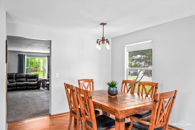 1118 Golden Oaks Pkwy, Aurora, IL 60506 - dining space with light wood finished floors, a chandelier, and baseboards