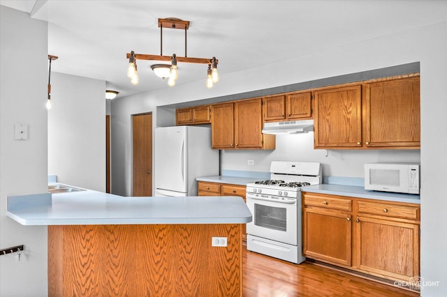 1118 Golden Oaks Pkwy, Aurora, IL 60506 - kitchen with white appliances, under cabinet range hood, brown cabinetry, light countertops, and a peninsula
