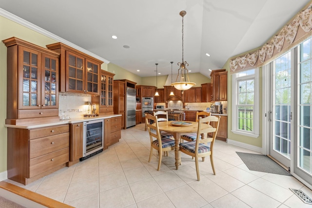 dining room with wine cooler, lofted ceiling, light tile patterned floors, plenty of natural light, and baseboards